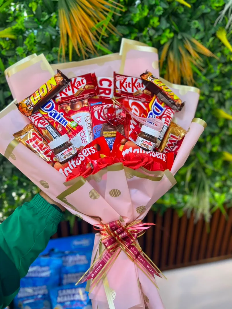 🎀 باقة شهية ومميزة تحتوي على تشكيلة من الشوكولاتة والحلويات مثل KitKat وMars وMaltesers وLion وTwix وNutella وغيرها. 🍫✨